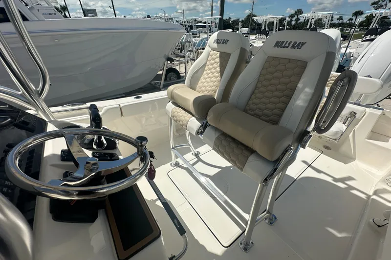 Slide: The Image of 2027 Bulls Bay 255 Center Console boat interior with steering wheel and cushioned seats. - 14