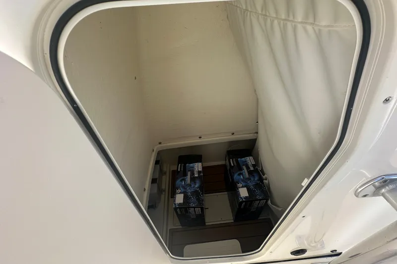 Slide: The Image of Storage compartment inside 2027 Bulls Bay 255 Center Console boat, containing two battery boxes. - 13