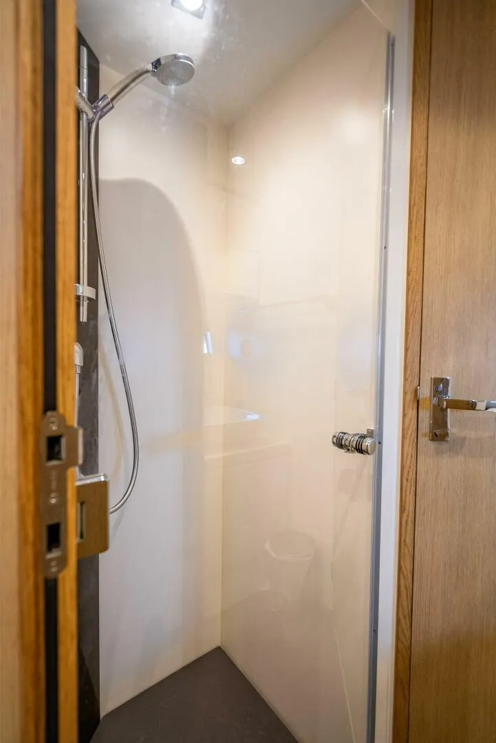 Slide: The Image of Shower area in 2015 Fairline Targa 48 Open yacht, featuring modern fixtures and wooden door. - 13