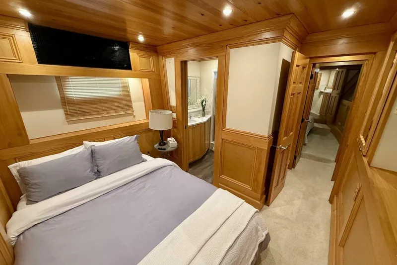 Slide: The Image of Luxurious wooden interior of 2018 Avenger Custom Catamaran bedroom with cozy bed and ambient lighting. - 28