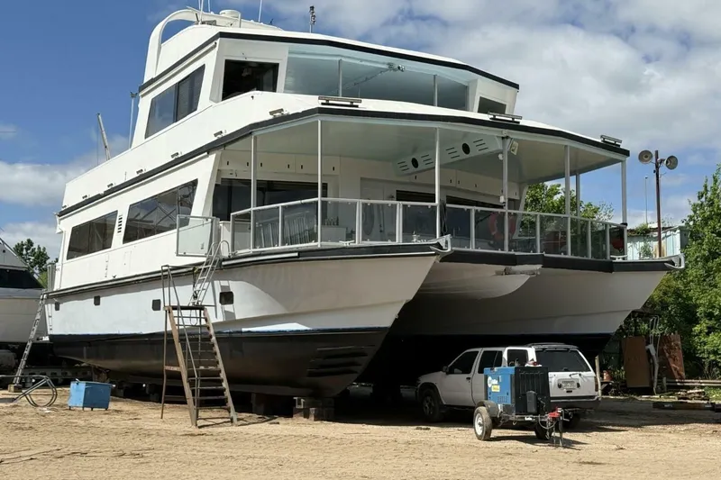 Slide: The Image of 2018 Avenger Custom Luxury Catamaran Coastal Cruiser on land, with a vehicle nearby. - 42