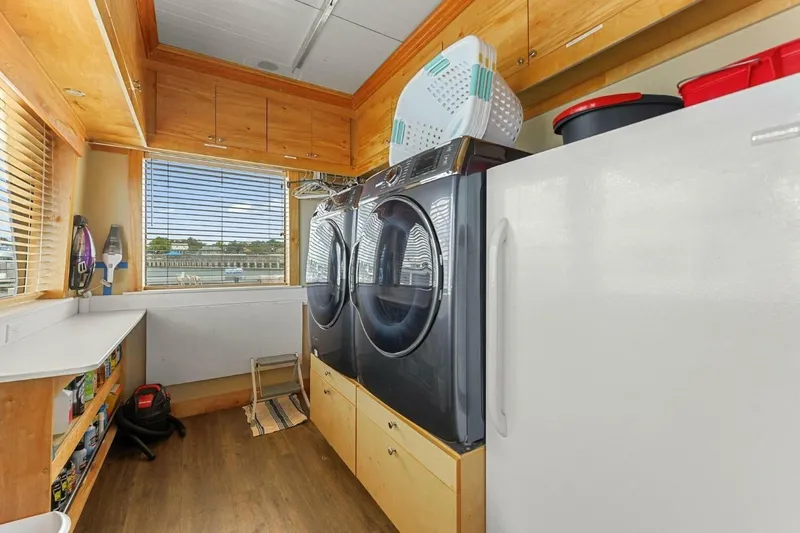 Slide: The Image of Laundry room on 2018 Avenger Custom Luxury Catamaran with washer, dryer, and storage cabinets. - 35