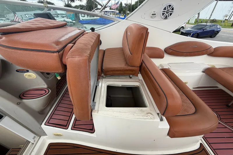 Slide: The Image of 2003 Maxum 2900 SE boat interior with brown leather seating and storage compartment. - 32