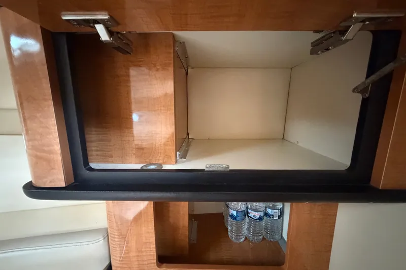 Slide: The Image of Interior storage compartment of 2003 Maxum 2900 SE boat with water bottles. - 72