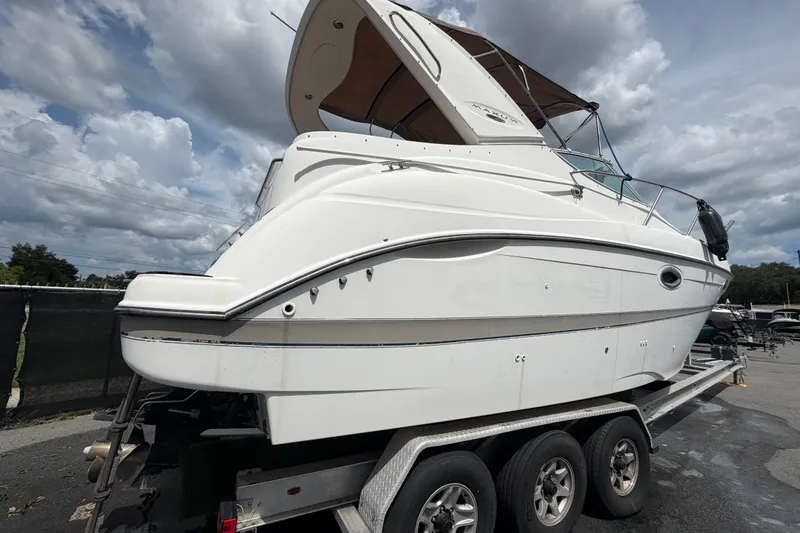 Slide: The Image of 2003 Maxum 2900 SE boat on trailer under cloudy sky. - 2