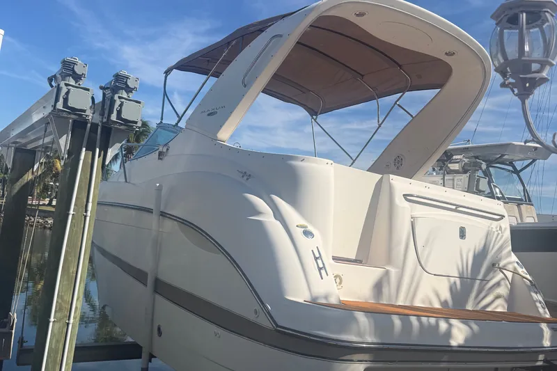 Slide: The Image of 2003 Maxum 2900 SE boat docked under a clear blue sky. - 2