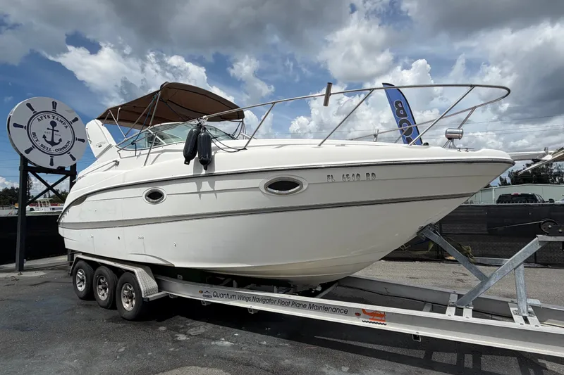 The Image of 2003 Maxum 2900 SE boat on trailer under cloudy sky at marina. - 0