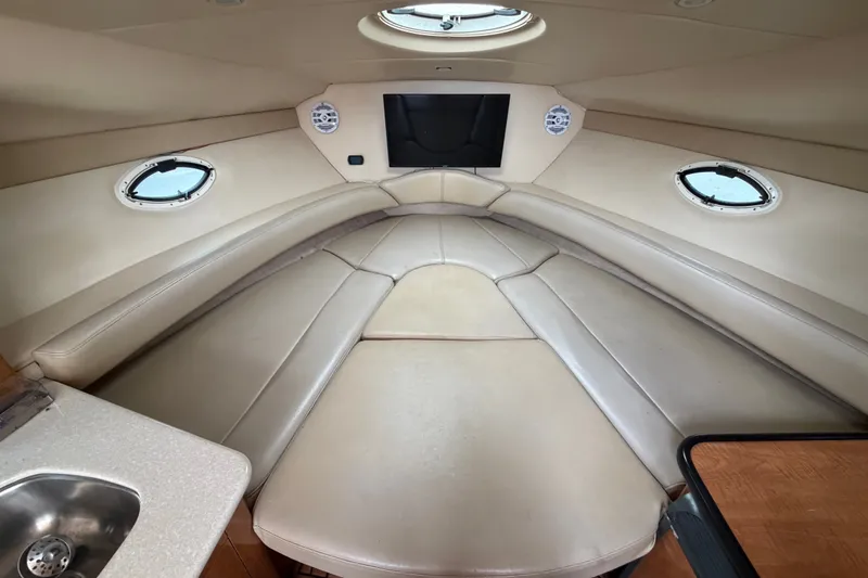 Slide: The Image of 2003 Maxum 2900 SE boat interior with beige seating and portholes. - 66