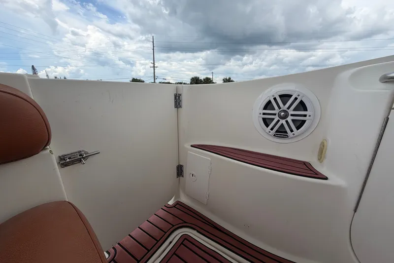 Slide: The Image of 2003 Maxum 2900 SE boat interior with speaker, brown seating, and cloudy sky background. - 91