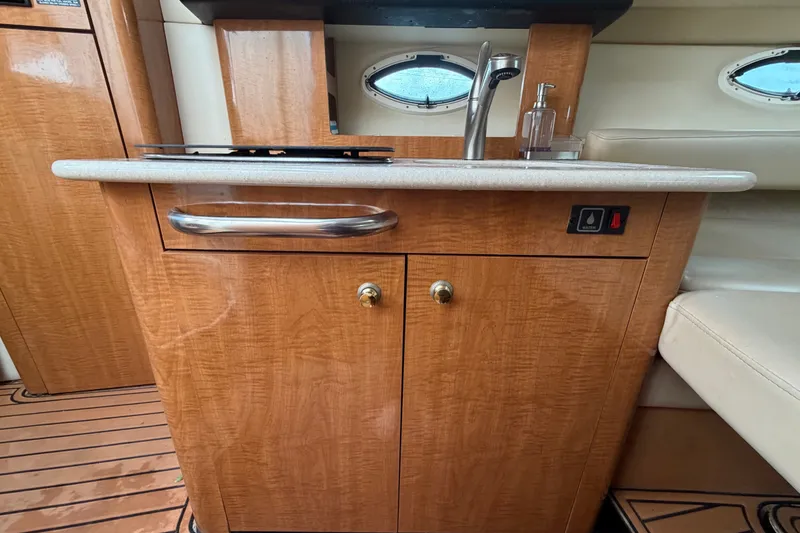 Slide: The Image of 2003 Maxum 2900 SE boat interior with wooden cabinetry and sink. - 64