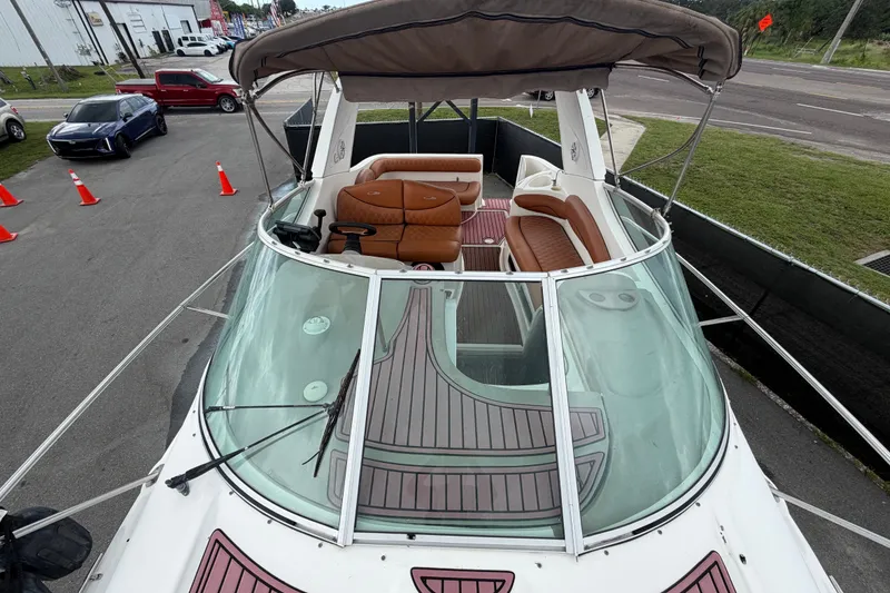 Slide: The Image of 2003 Maxum 2900 SE boat with spacious seating and canopy, parked near road. - 48