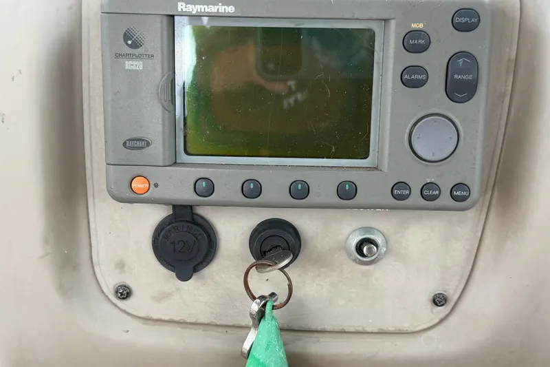 Slide: The Image of Raymarine chartplotter on 2003 Maxum 2900 SE boat dashboard with ignition key. - 40