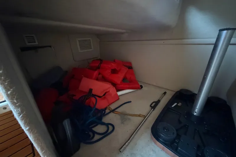 Slide: The Image of Storage compartment of 2003 Maxum 2900 SE boat with life jackets and equipment. - 85