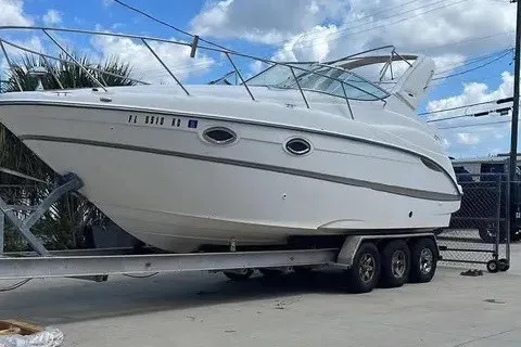 Slide: The Image of 2003 Maxum 2900 SE boat on a trailer, parked outdoors under a cloudy sky. - 3