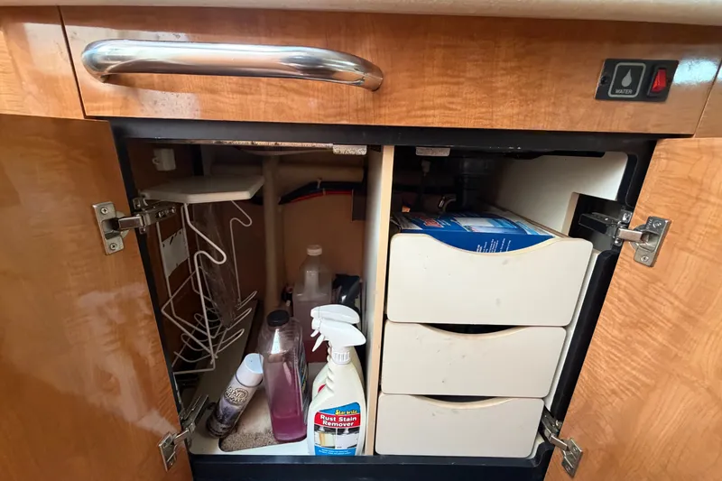 Slide: The Image of Under-sink storage in 2003 Maxum 2900 SE boat with cleaning supplies and drawers. - 65