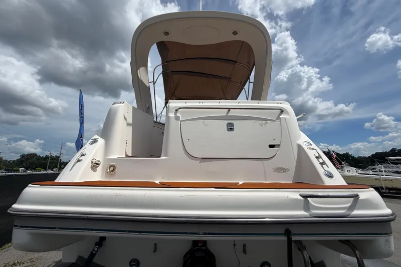 Slide: The Image of 2003 Maxum 2900 SE boat, rear view under cloudy sky, showcasing swim platform and canopy. - 3