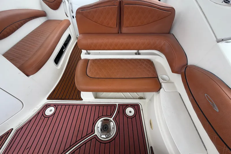 Slide: The Image of 2003 Maxum 2900 SE boat interior with brown leather seating and wood-patterned flooring. - 23