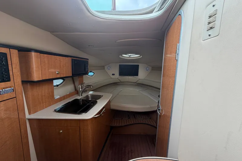 Slide: The Image of 2003 Maxum 2900 SE cabin interior with kitchenette and seating area. - 53