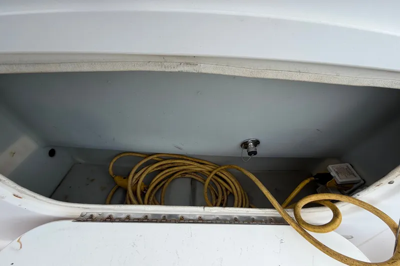 Slide: The Image of Storage compartment of a 2003 Maxum 2900 SE boat with coiled yellow cable. - 17
