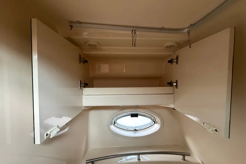 Slide: The Image of Interior storage cabinets and porthole in 2003 Maxum 2900 SE boat. - 79