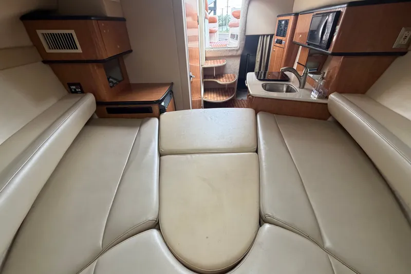 Slide: The Image of 2003 Maxum 2900 SE cabin interior with seating, kitchenette, and wooden accents. - 68