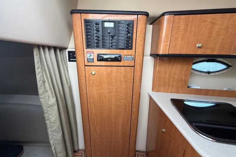 Slide: The Image of 2003 Maxum 2900 SE cabin interior with control panel and wooden cabinetry. - 54
