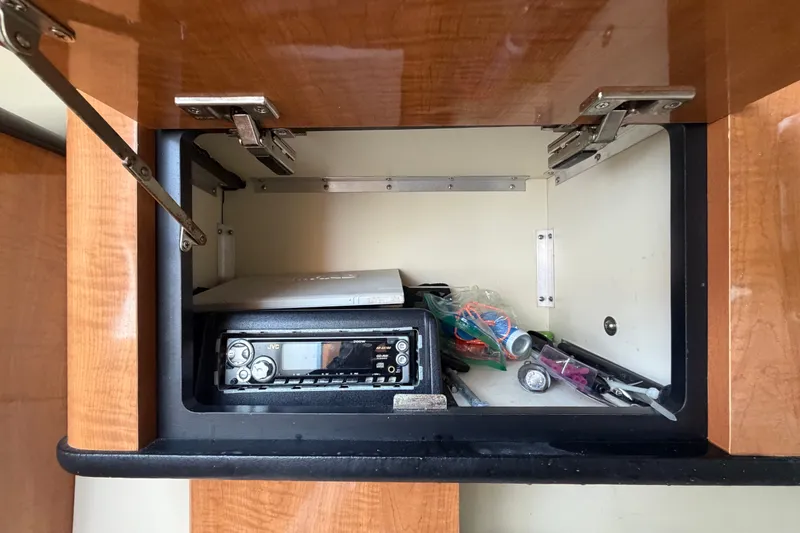 Slide: The Image of Open cabinet in 2003 Maxum 2900 SE boat with stereo and miscellaneous items. - 62