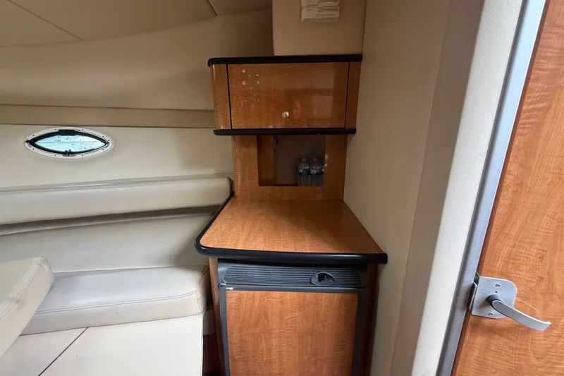 Slide: The Image of Interior of 2003 Maxum 2900 SE boat with wood cabinetry and compact fridge. - 70