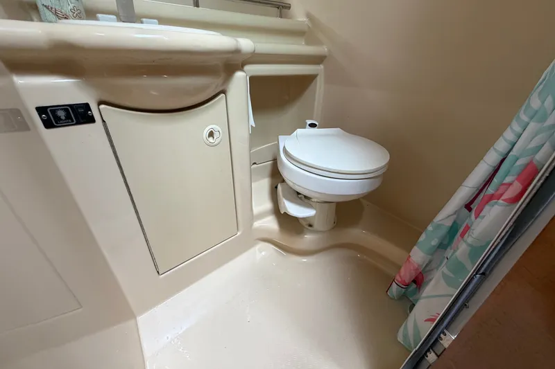 Slide: The Image of 2003 Maxum 2900 SE boat bathroom with toilet and shower curtain. - 80