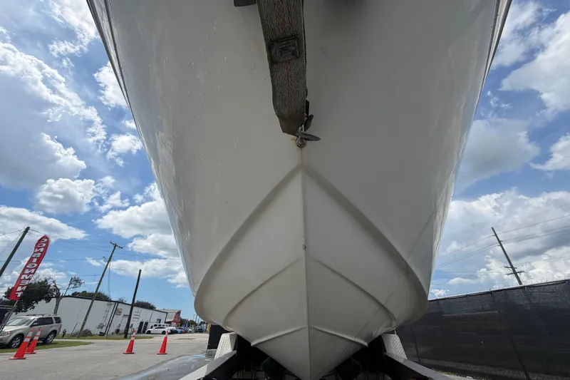 Slide: The Image of 2003 Maxum 2900 SE boat hull viewed from below, against a cloudy sky. - 13