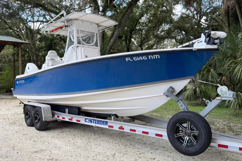 Slide: The Image of 2007 Contender 23 Tournament boat on trailer, blue hull, parked outdoors. - 4