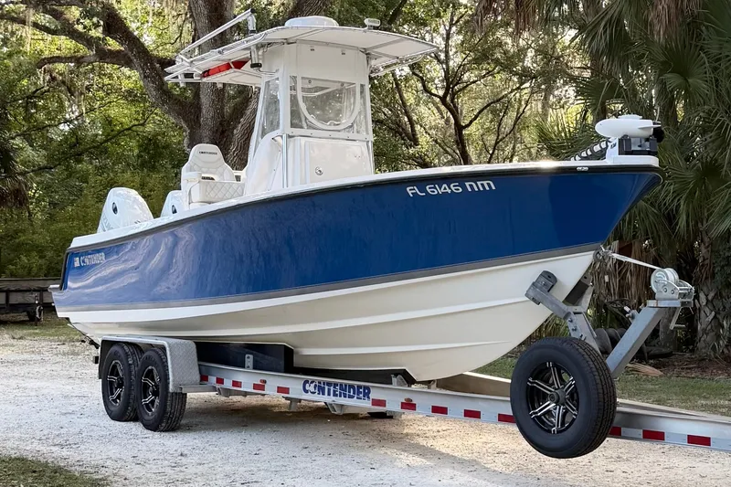 Slide: The Image of 2007 Contender 23 Tournament boat on trailer, parked in a wooded area. - 1