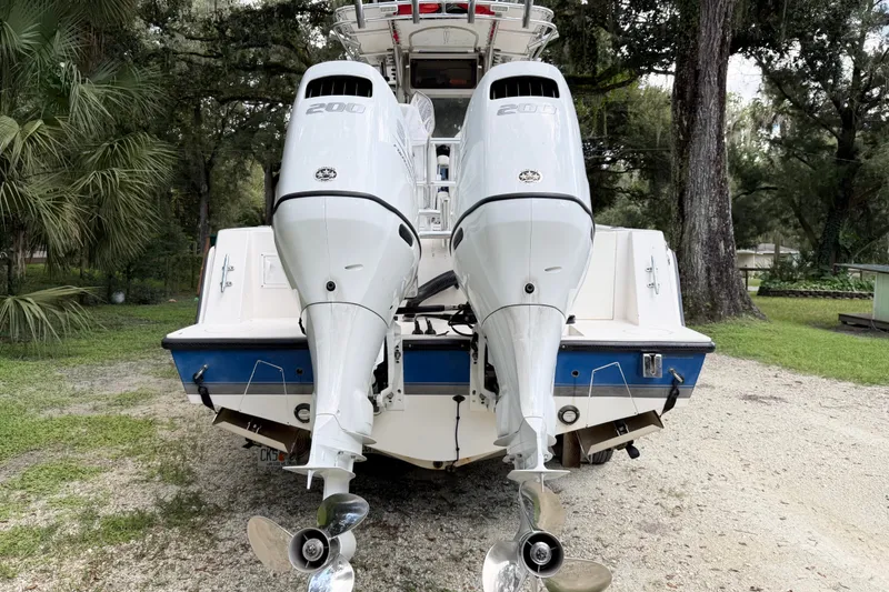 Slide: The Image of 2007 Contender 23 Tournament boat with dual outboard engines, parked on gravel. - 3