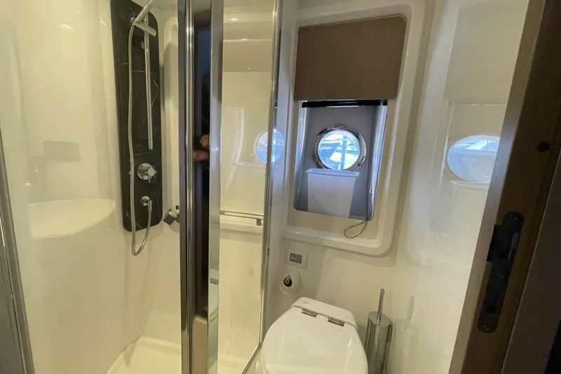 Slide: The Image of Guest bathroom interior of 2023 Azimut Fly 50 yacht, featuring shower and porthole window. - 8