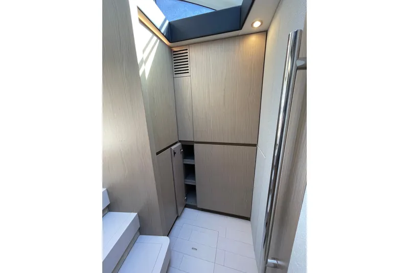 Slide: The Image of Modern interior of hidden washer/dryer and freezer in 2023 Azimut Fly 50 yacht with sleek wood cabinetry. - 6