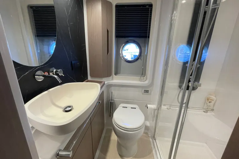 Slide: The Image of Luxurious master bathroom in 2023 Azimut Fly 50 yacht with modern fixtures and porthole window. - 16
