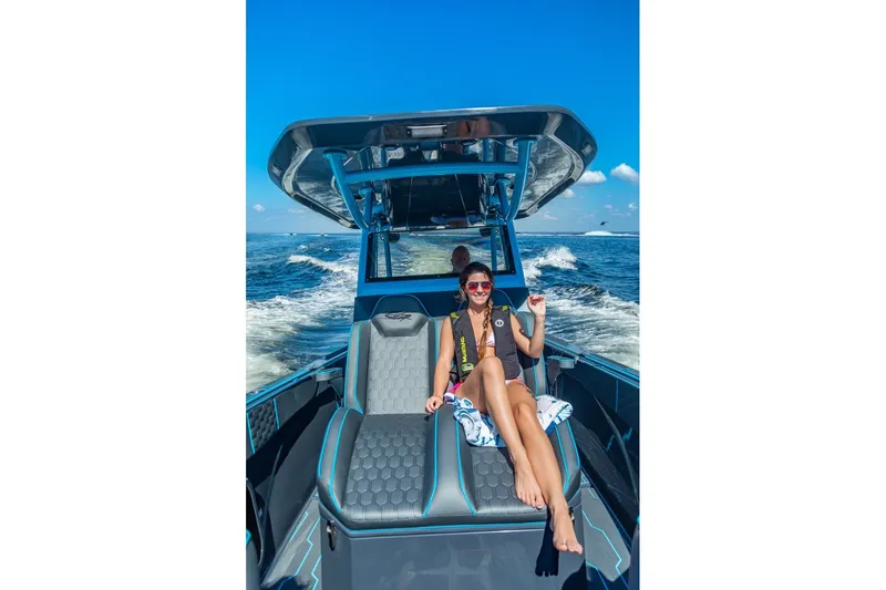 Slide: The Image of Woman relaxing on a 2025 Glasstream 32 GSX boat, enjoying a sunny day at sea. - 7