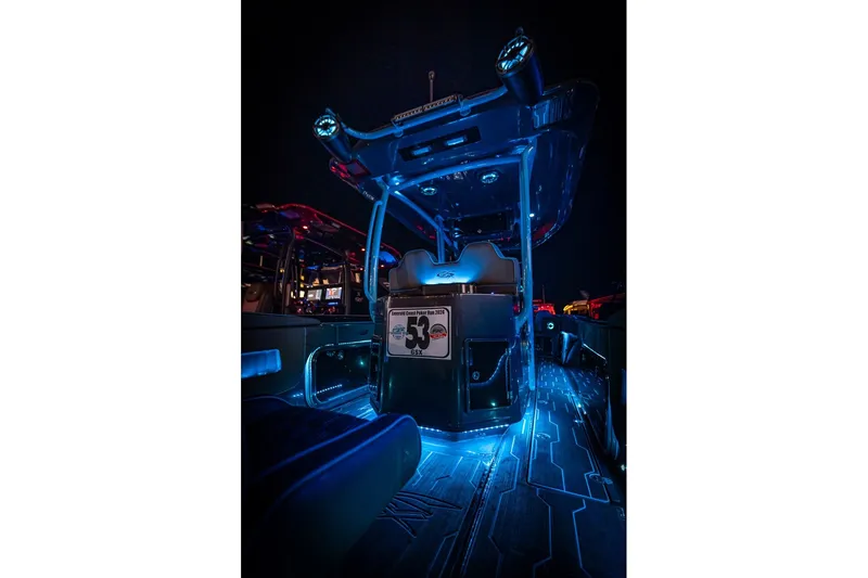 Slide: The Image of 2025 Glasstream 32 GSX boat interior with vibrant blue LED lighting at night. - 17