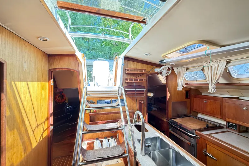 Slide: The Image of Interior of 2000 Hunter 460 sailboat with wooden cabinetry and stainless steel fixtures. - 24