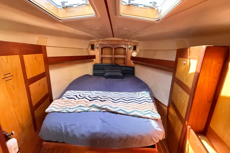 Slide: The Image of Cozy cabin interior of 2000 Hunter 460 sailboat with bed and wooden storage. - 53