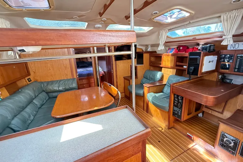 Slide: The Image of Interior of a 2000 Hunter 460 yacht with wood finish and green seating. - 36