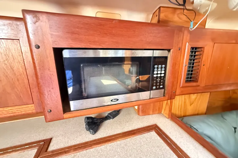 Slide: The Image of Built-in microwave in a 2000 Hunter 460 yacht's wooden interior kitchen. - 34