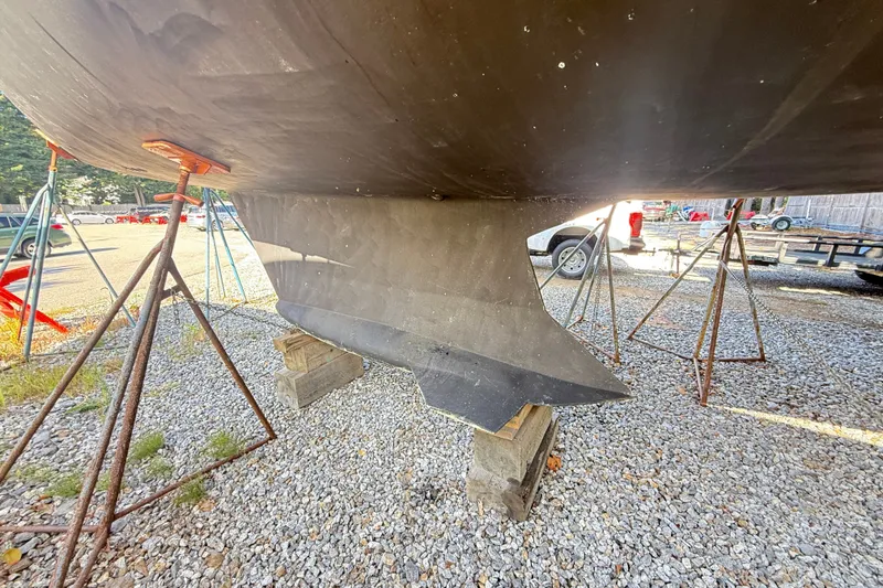 Slide: The Image of Keel of a 2000 Hunter 460 sailboat on stands in a gravel yard. - 71