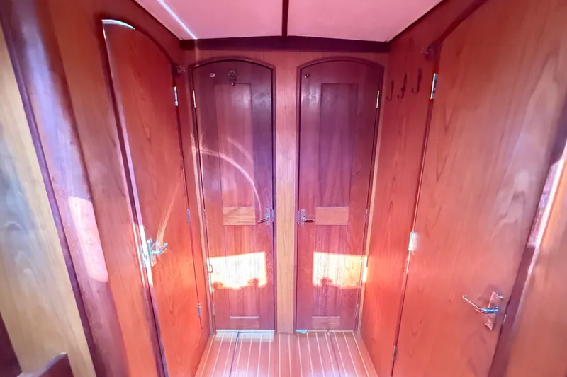 Slide: The Image of Wooden interior of a 2000 Hunter 460 yacht, featuring polished doors and warm lighting. - 64