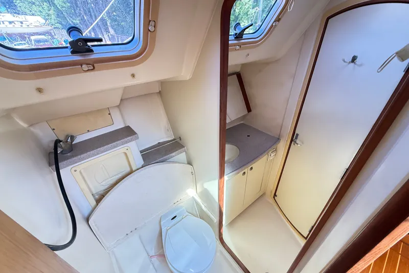 Slide: The Image of Interior of 2000 Hunter 460 yacht bathroom with sink, toilet, and window. - 39
