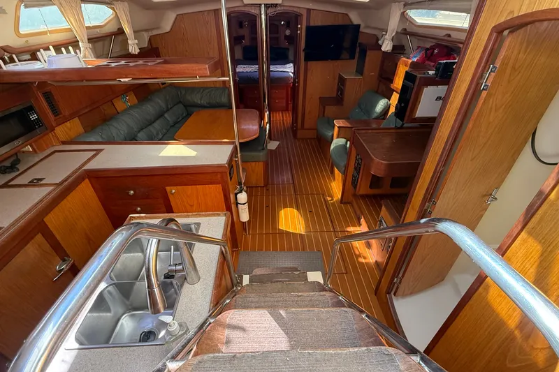 Slide: The Image of Interior of a 2000 Hunter 460 sailboat with wood finish and cozy seating area. - 23