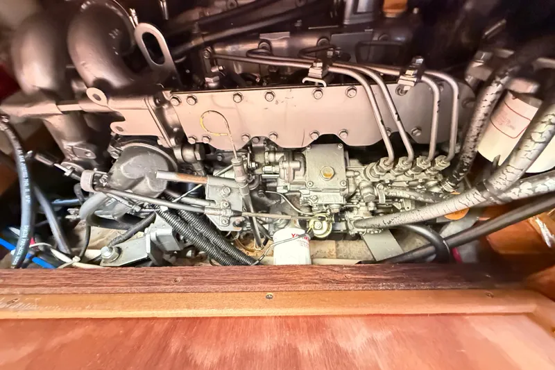 Slide: The Image of Engine compartment of a 2000 Hunter 460 sailboat, showcasing mechanical components and wiring. - 69