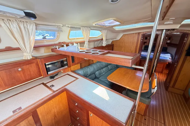 Slide: The Image of Interior of a 2000 Hunter 460 yacht with wood finishes and cozy seating area. - 35