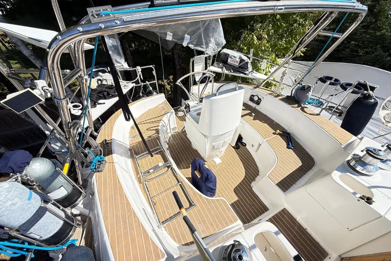 Slide: The Image of Deck view of a 2000 Hunter 460 sailboat with wooden flooring and steering wheel. - 17