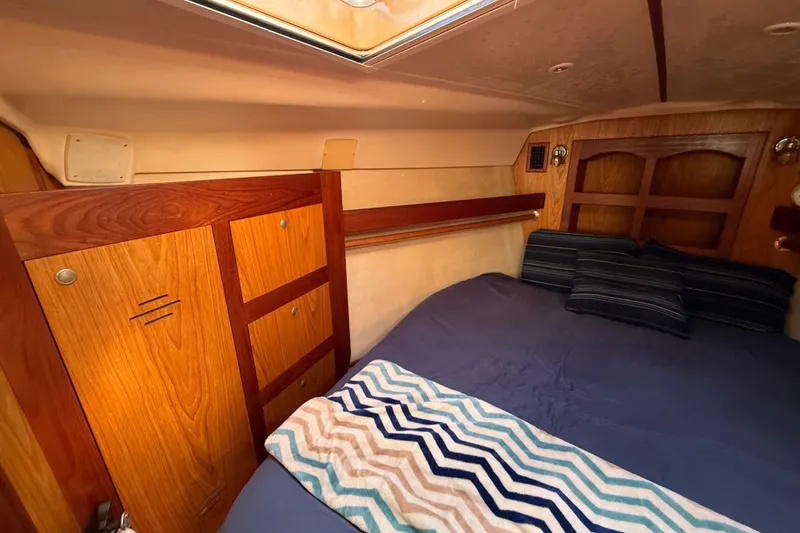 Slide: The Image of Cozy cabin interior of 2000 Hunter 460 sailboat with wooden cabinetry and comfortable bedding. - 54